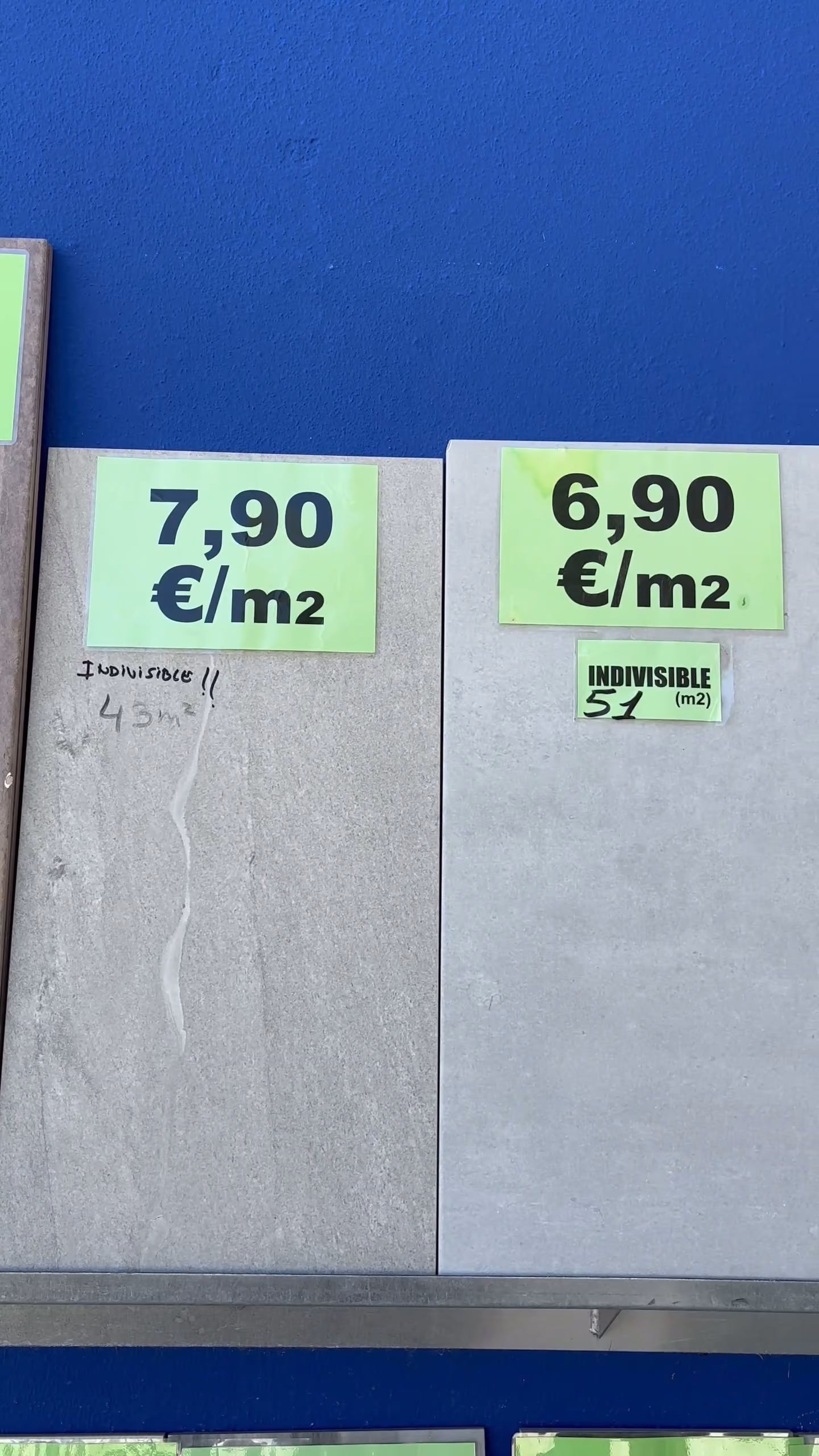 Dos piezas de gres de gran formato con sus etiquetas verdes de precio por metro cuadrado.