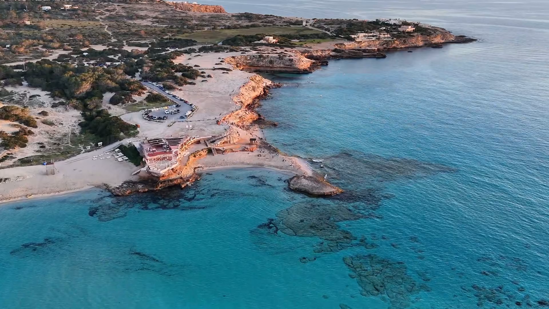 Vista aérea de una cala mediterránea al atardecer, grabada con dron por (in)tangibles