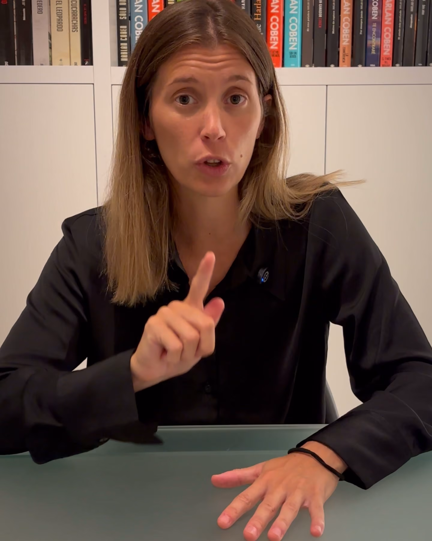 Grabación en el despacho de Tramita: una asesora explica a cámara una línea de subvenciones, con la estantería de libros al fondo.